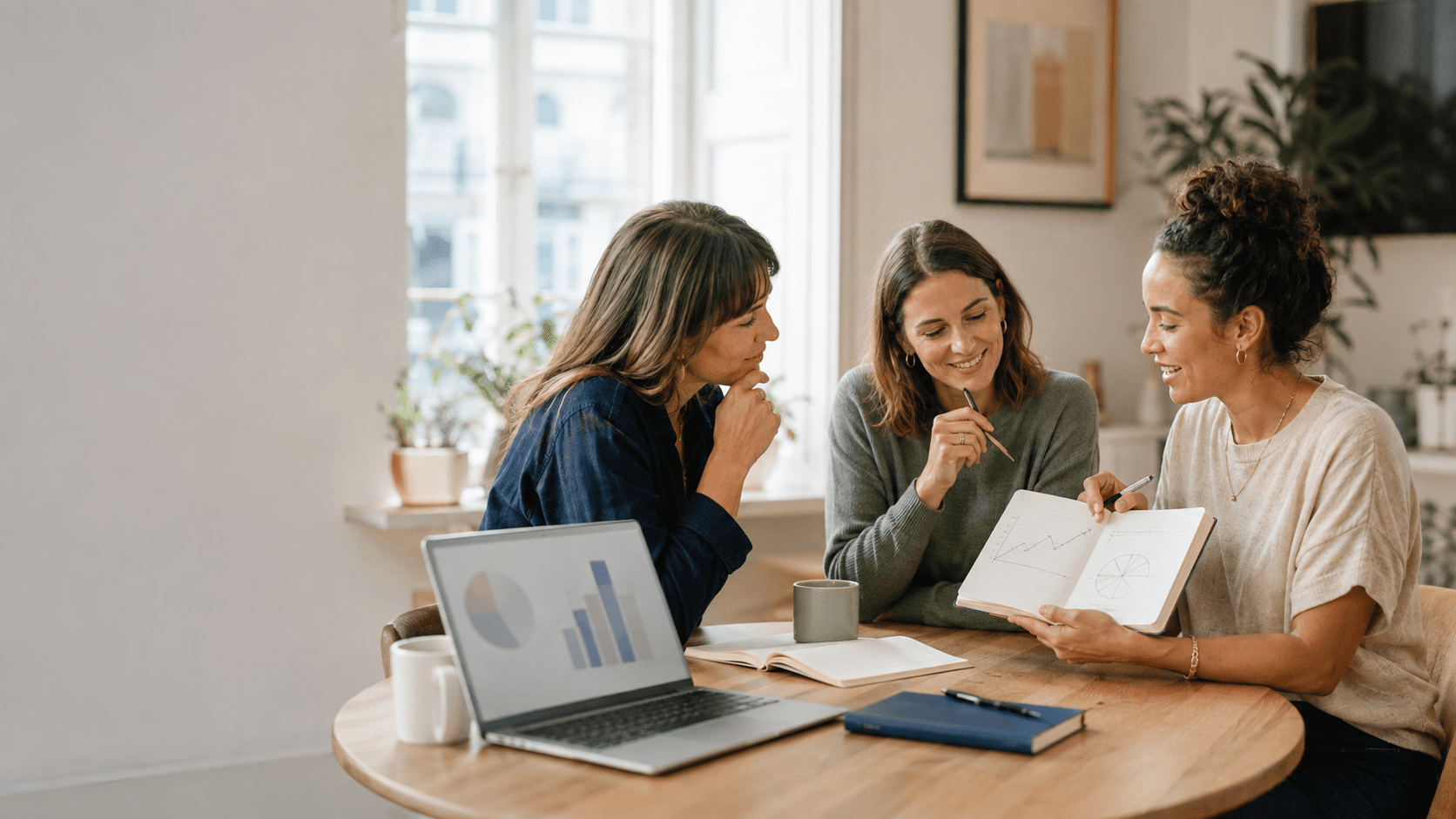 Drei Frauen besprechen gemeinsam Investment-Charts an einem Tisch